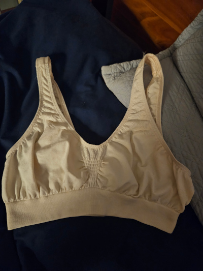 A cream-coloured bra on a bed A cream-coloured bra on a bed